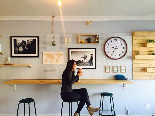 bar stool woman sitting on stall near wall mounted desk furniture